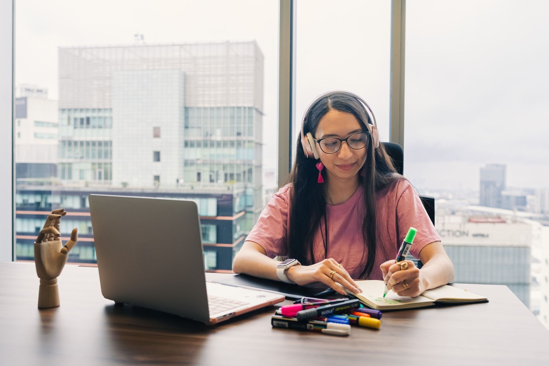 Woman with ADHD using headphones and color-coded notes to stay focused at her desk