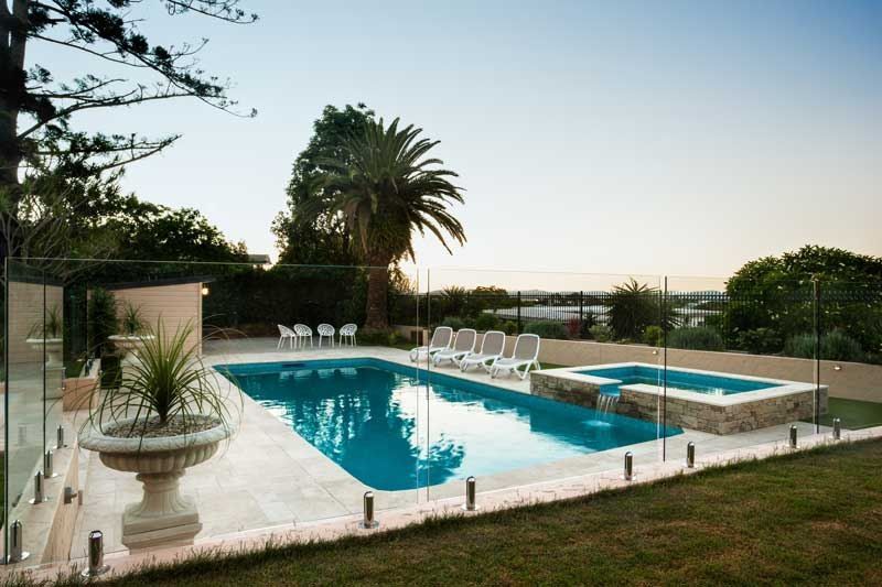 A Large Swimming Pool Surrounded by Chairs and Trees — Fencing Around In Mareeba, QLD