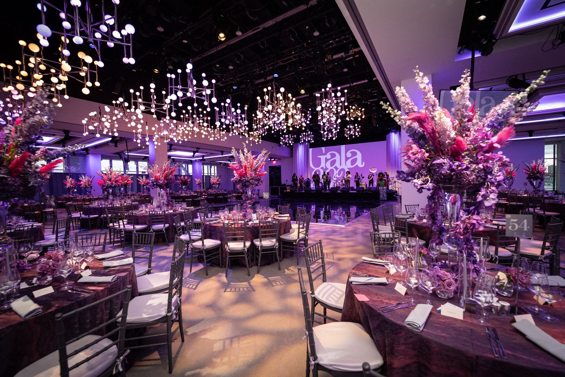 A large room with tables and chairs set up for a party.