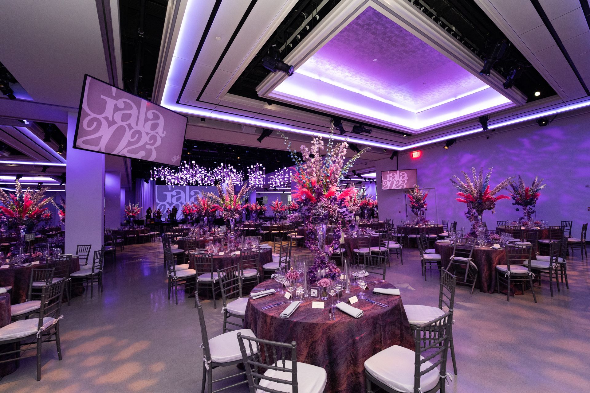 A large room with tables and chairs set up for a gala.