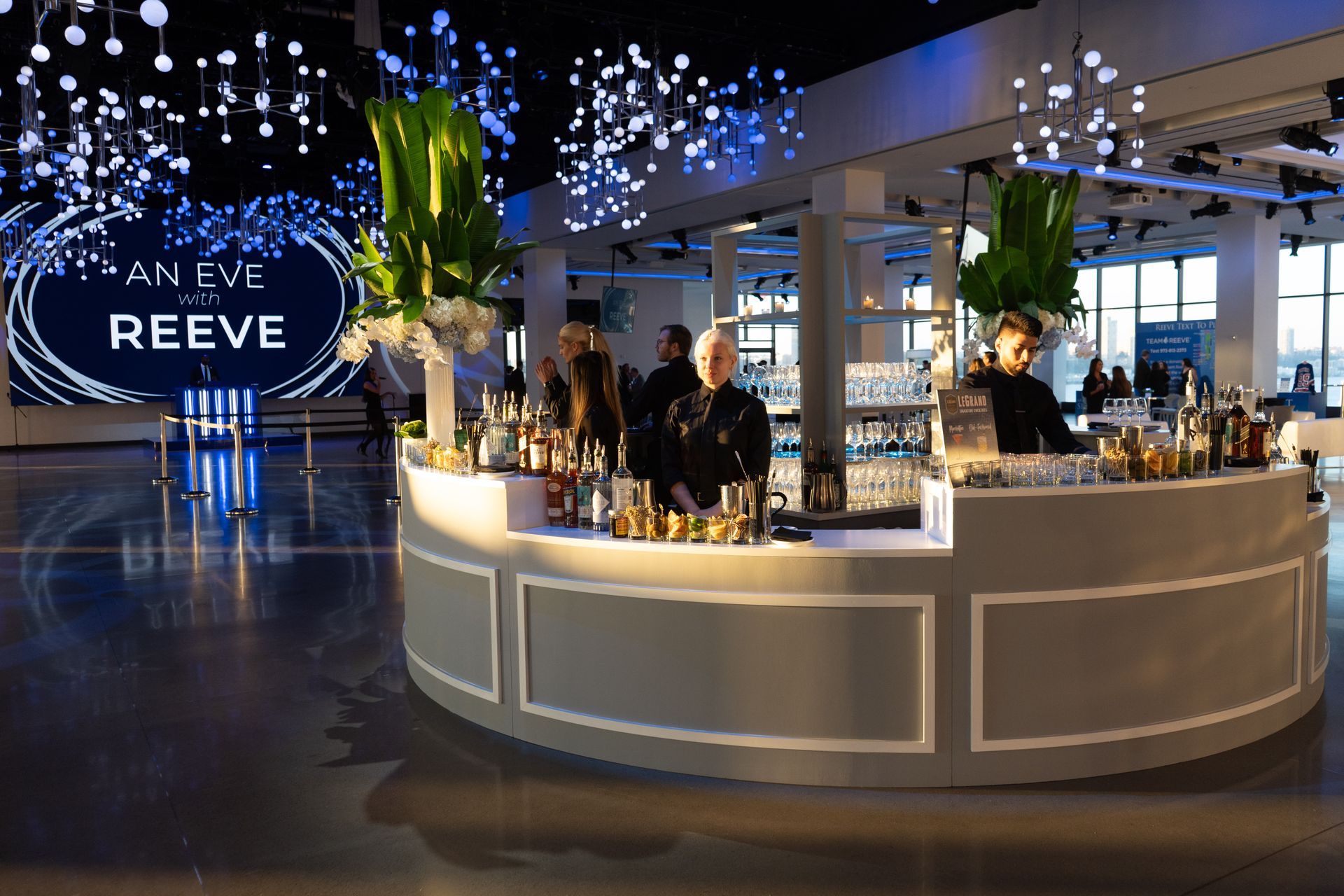 a group of people are standing around a bar in a large room .