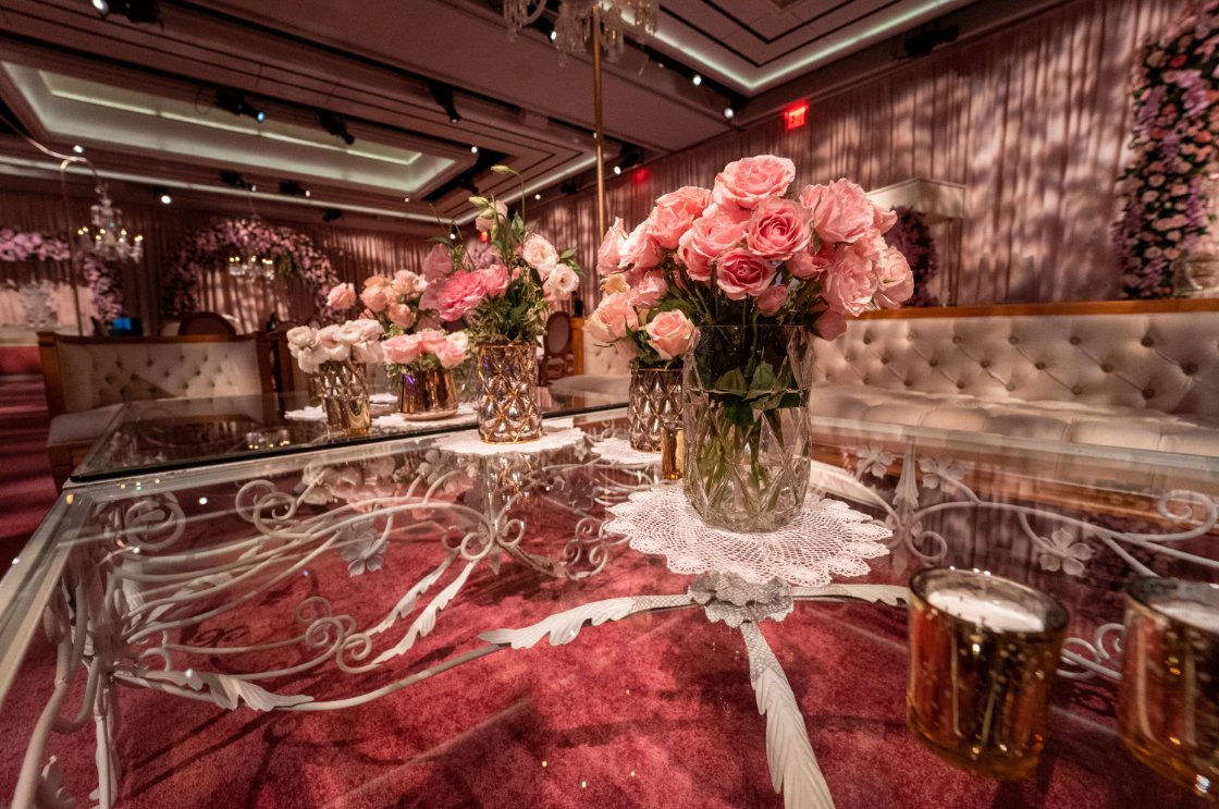a table with vases of flowers on it in a room .