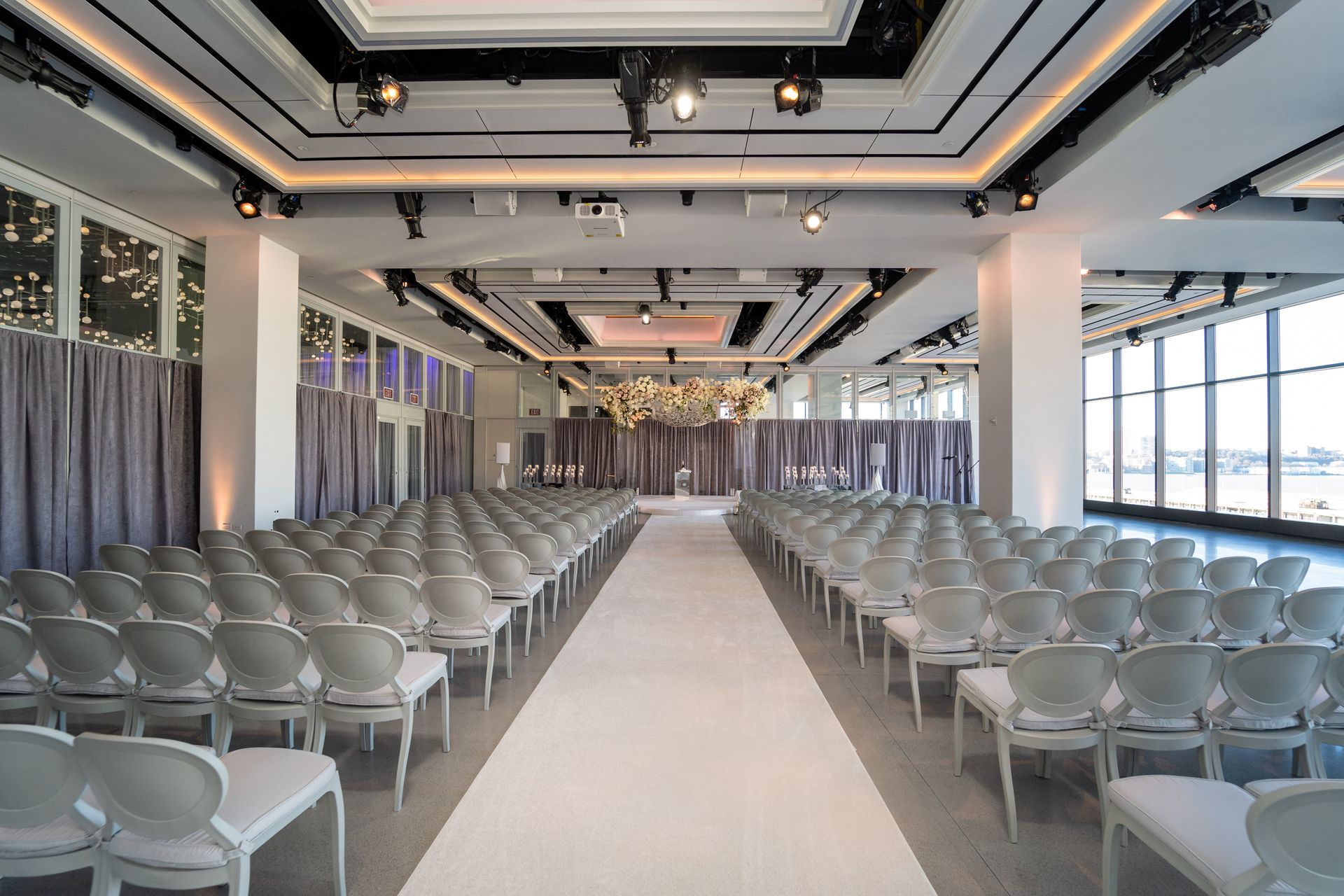 a large room with rows of chairs and a white carpet .