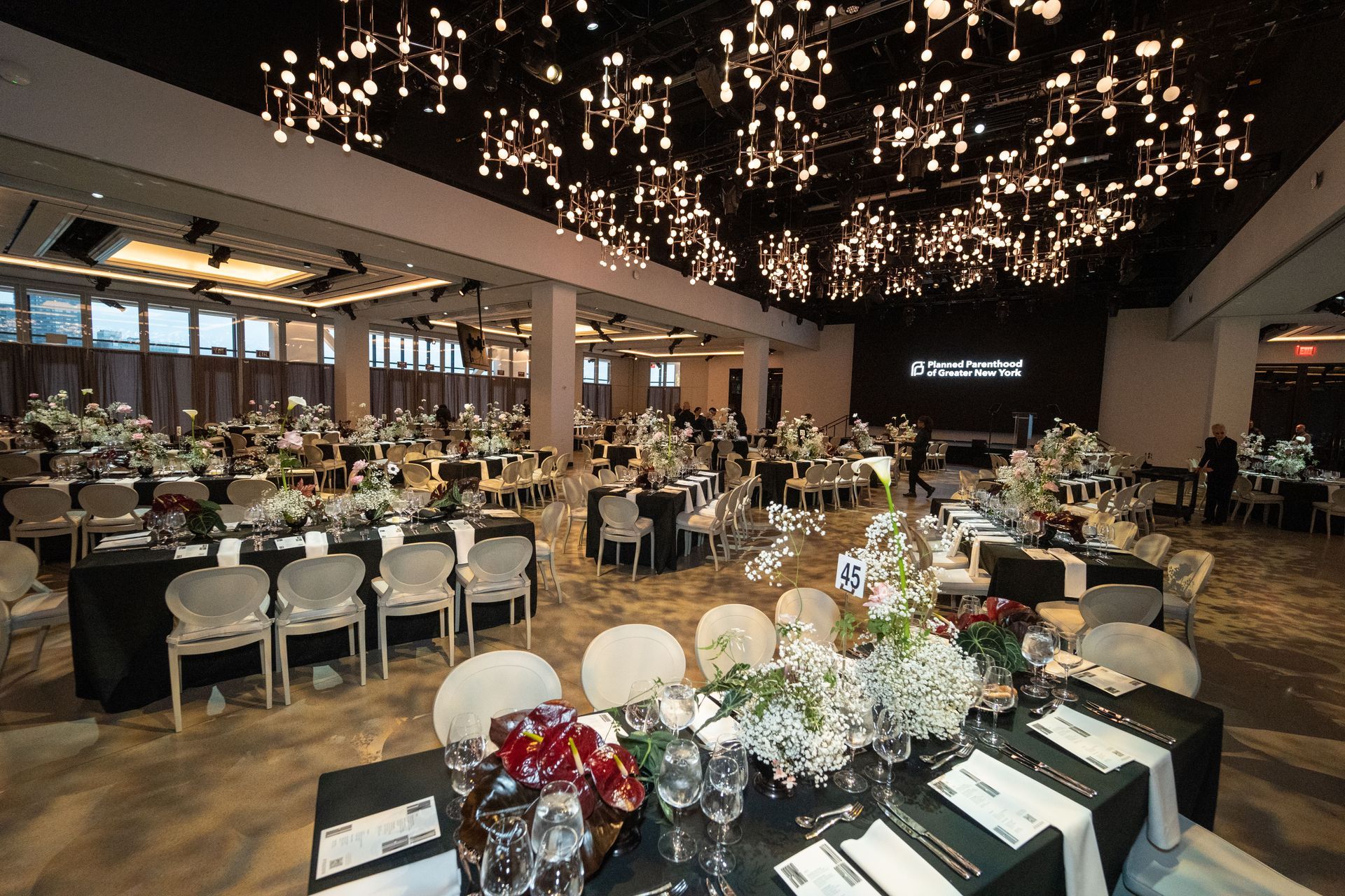 A large room with tables and chairs set up for a wedding reception.