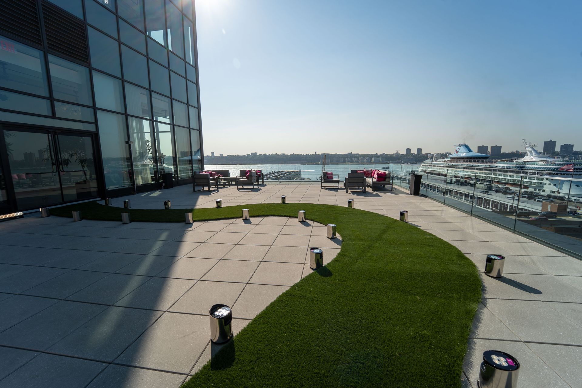 High line gala at The Glasshouse - a patio with a view of the water and a building in the background .