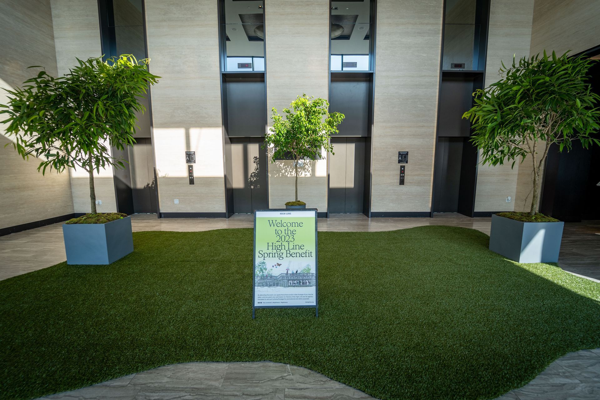 High line gala at The Glasshouse - a sign in front of a building with trees in pots .