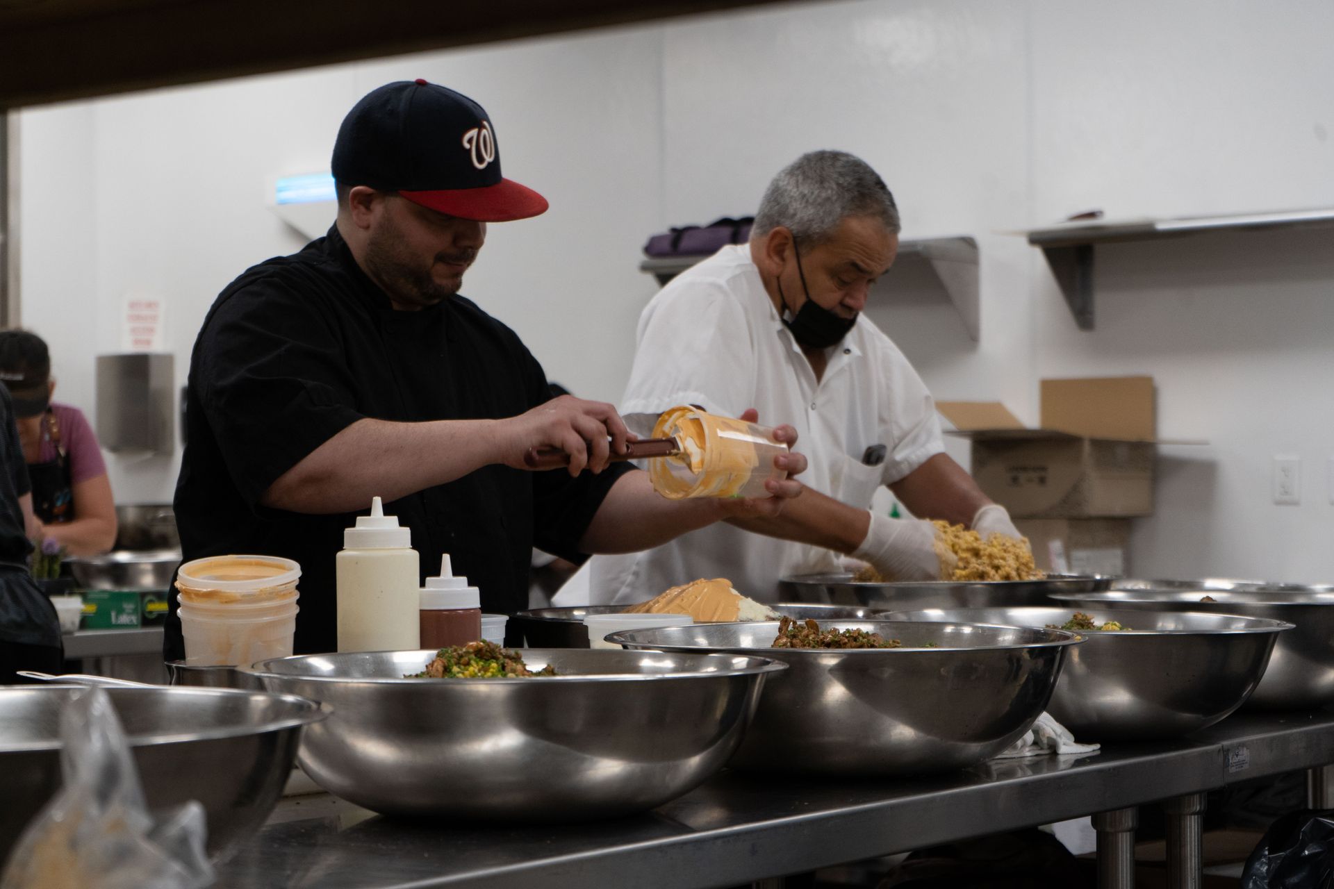 Two men are preparing food in a kitchen.