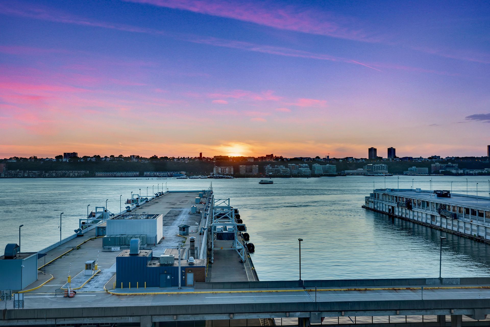 a sunset over a body of water with a dock in the foreground .