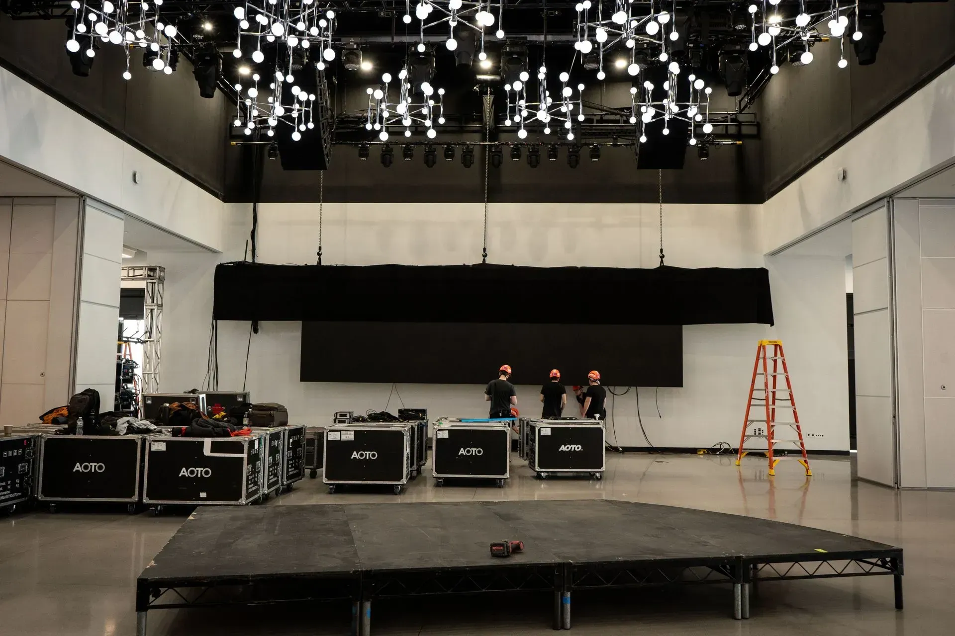 a large room with a stage and a ladder in it