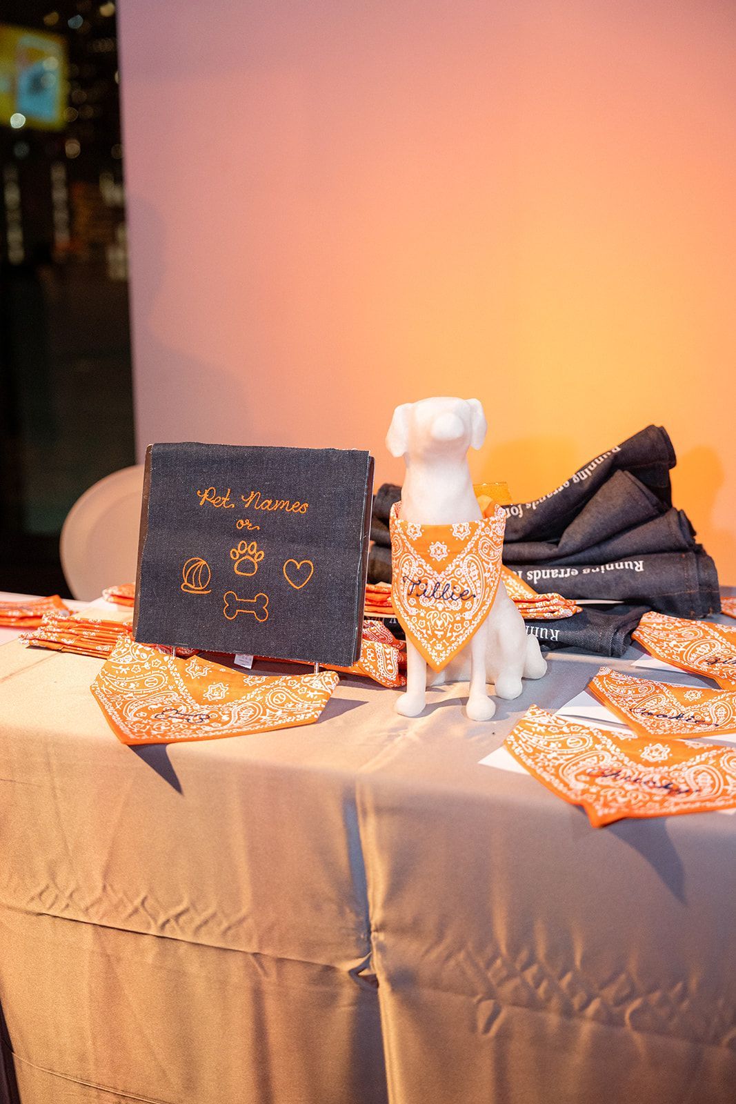 A display of dog bandanas and accessories on a table with a dog statue centerpiece.