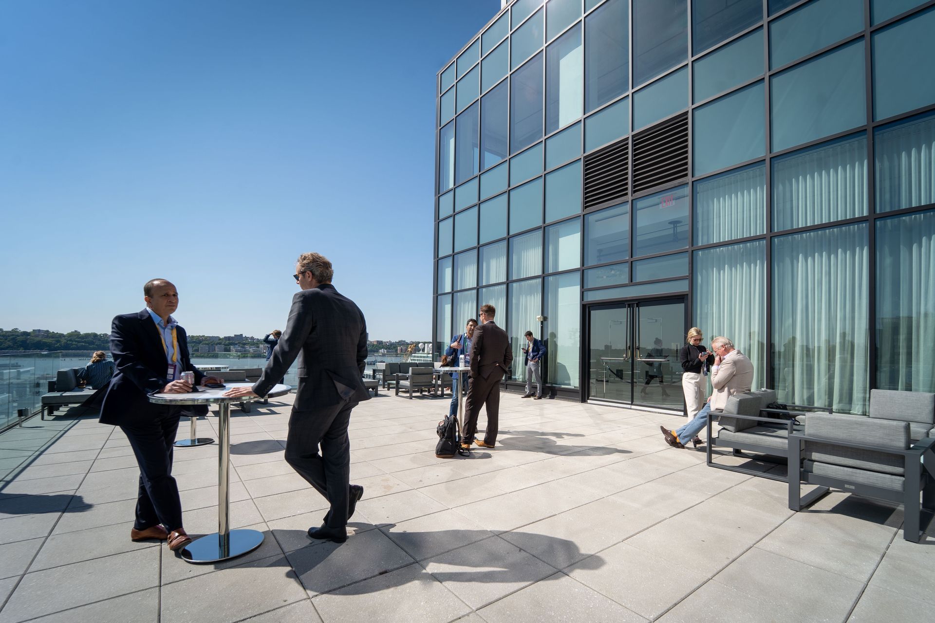 a group of people are standing on a patio in front of a building .