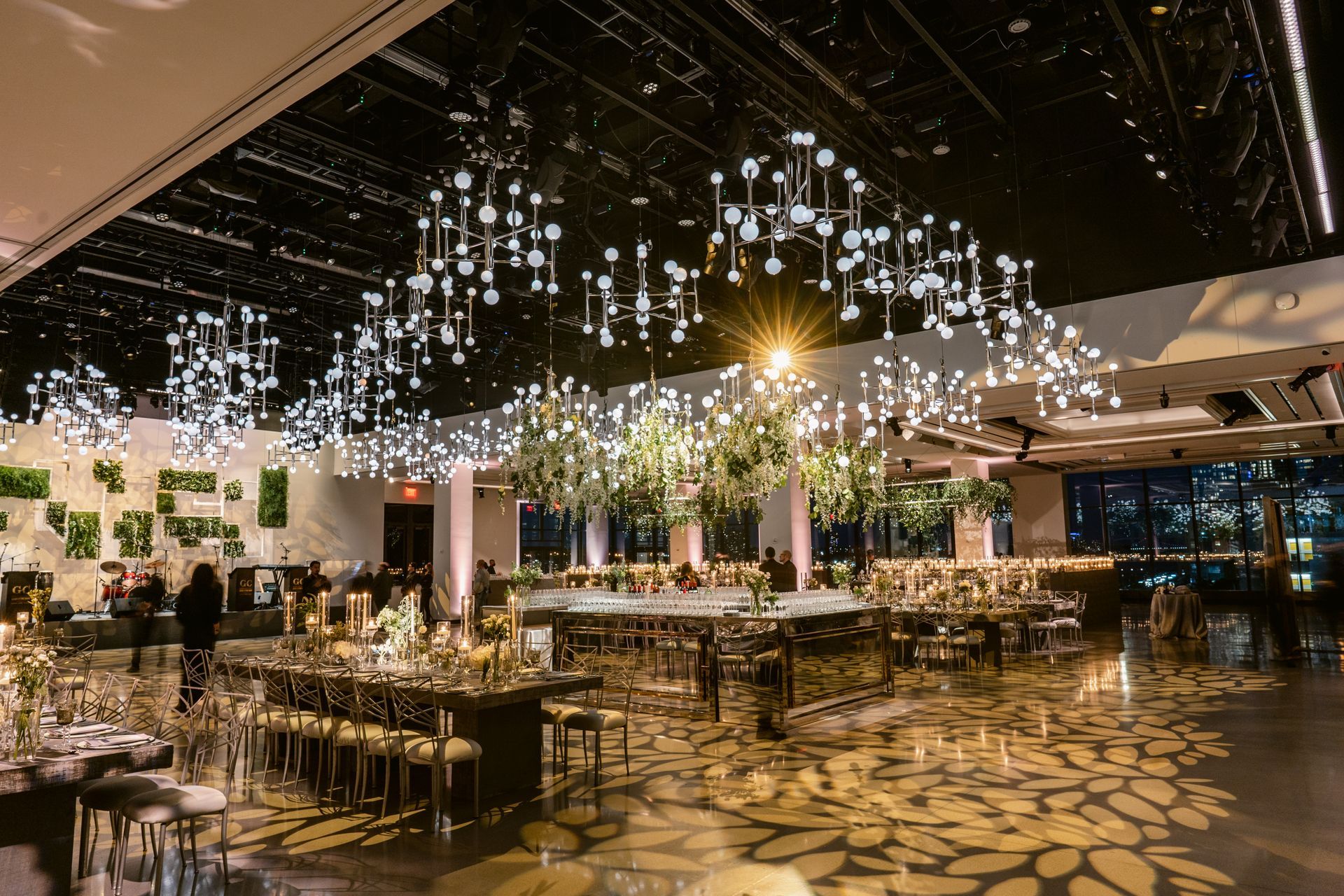 A large room with tables and chairs and a chandelier hanging from the ceiling.