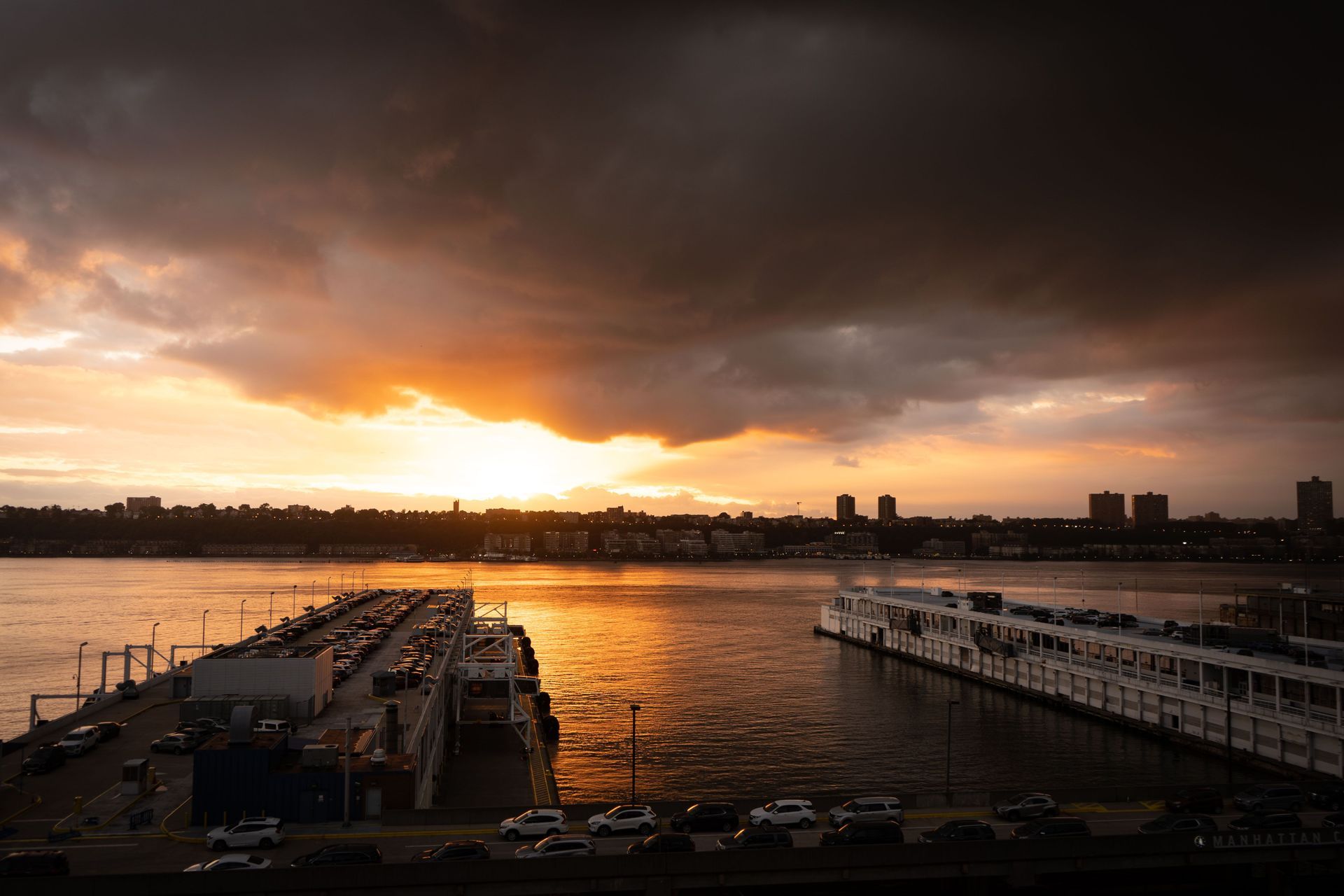 a sunset over a body of water with a boat in the foreground .