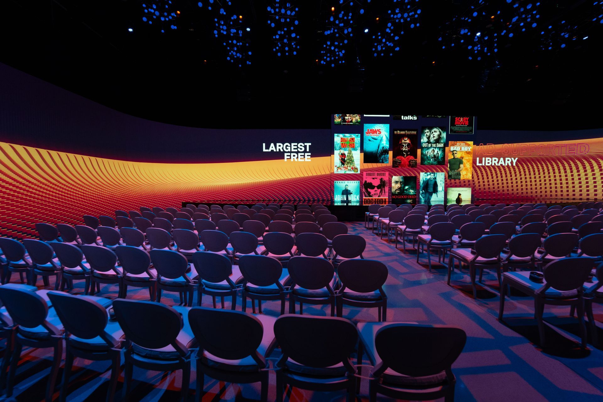An empty auditorium with rows of chairs and a large screen that says lawsuit