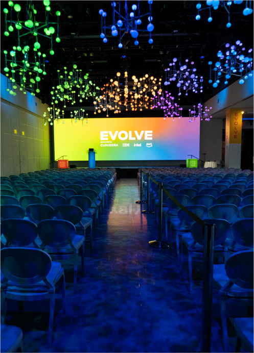 An empty auditorium with a large screen that says evolve