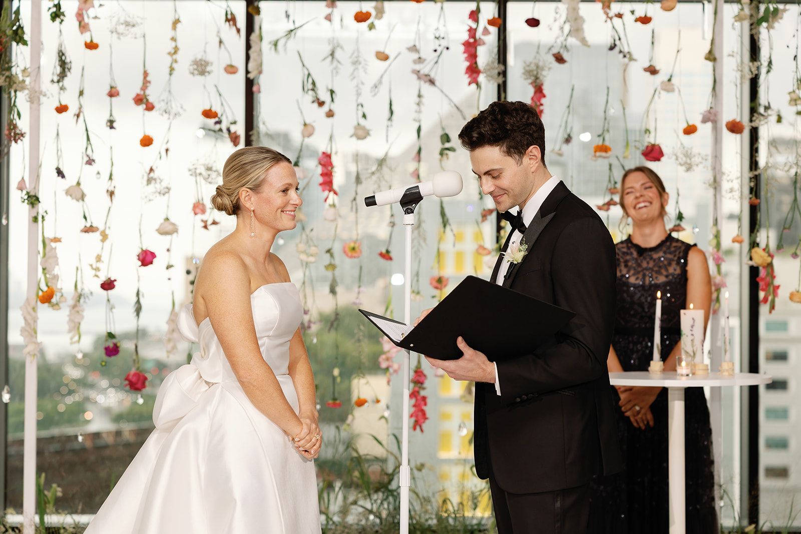 Bride and groom exchanging vows at an outdoor wedding ceremony with floral decorations