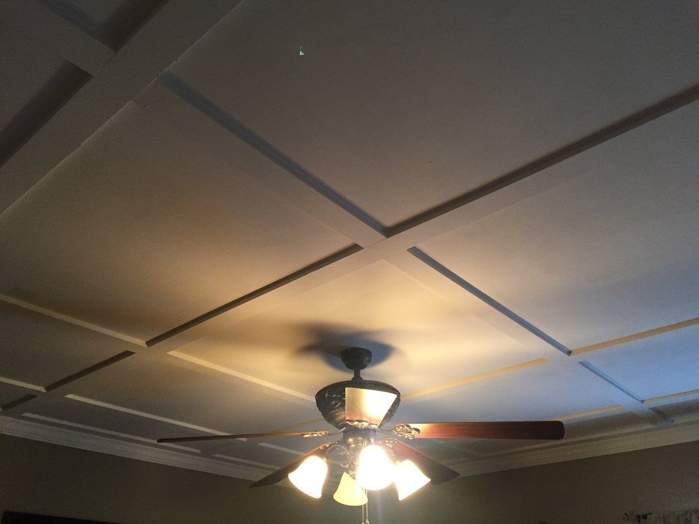 A ceiling fan with a four-light fixture hangs below a white coffered ceiling.