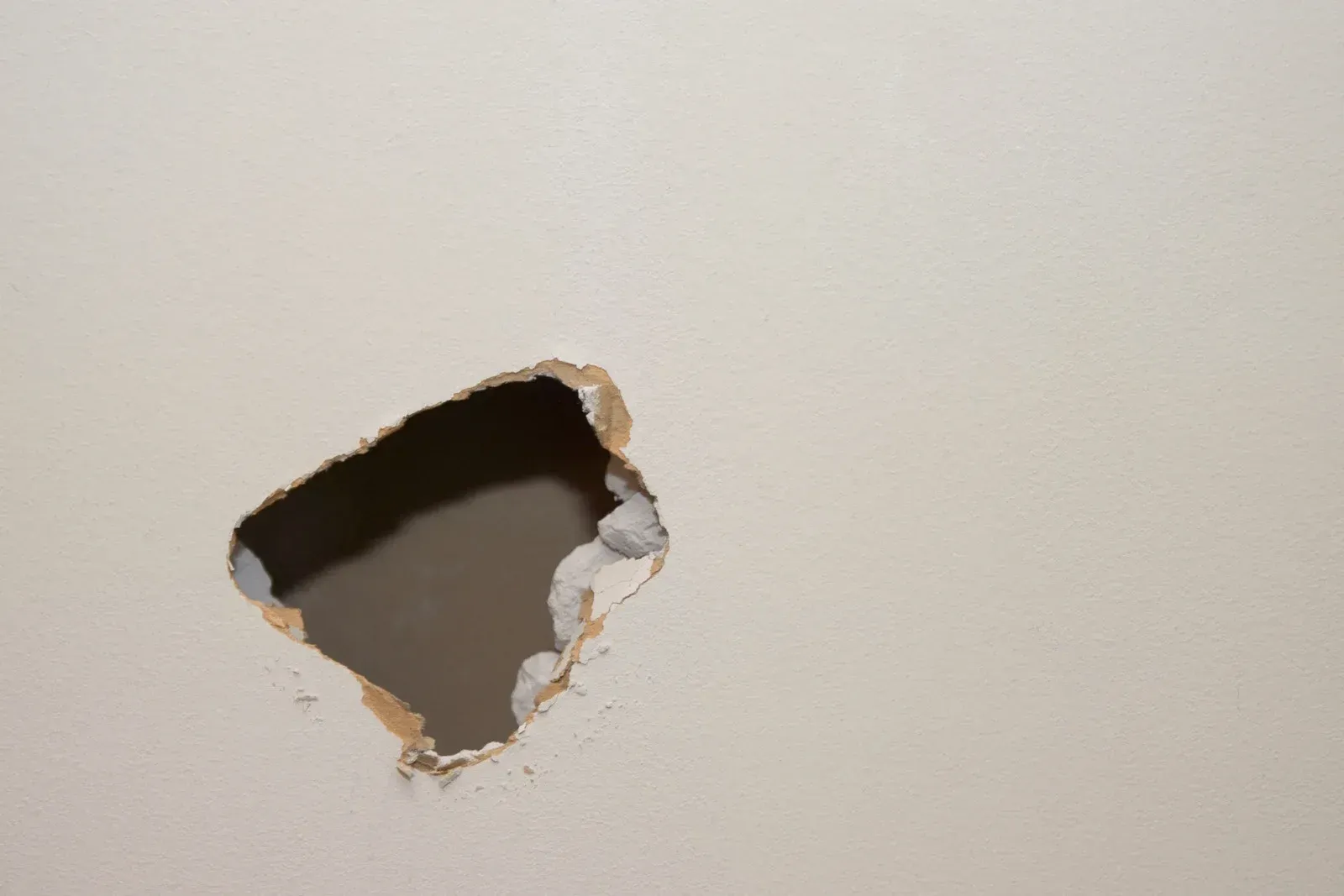 Interior view of unfinished room walls and a tray ceiling with visible drywall seams and mudding.
