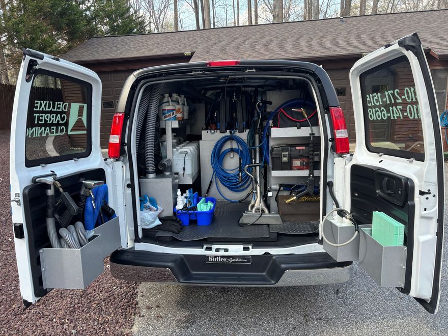 Open van with rear doors open, showing organized cleaning or repair equipment inside.