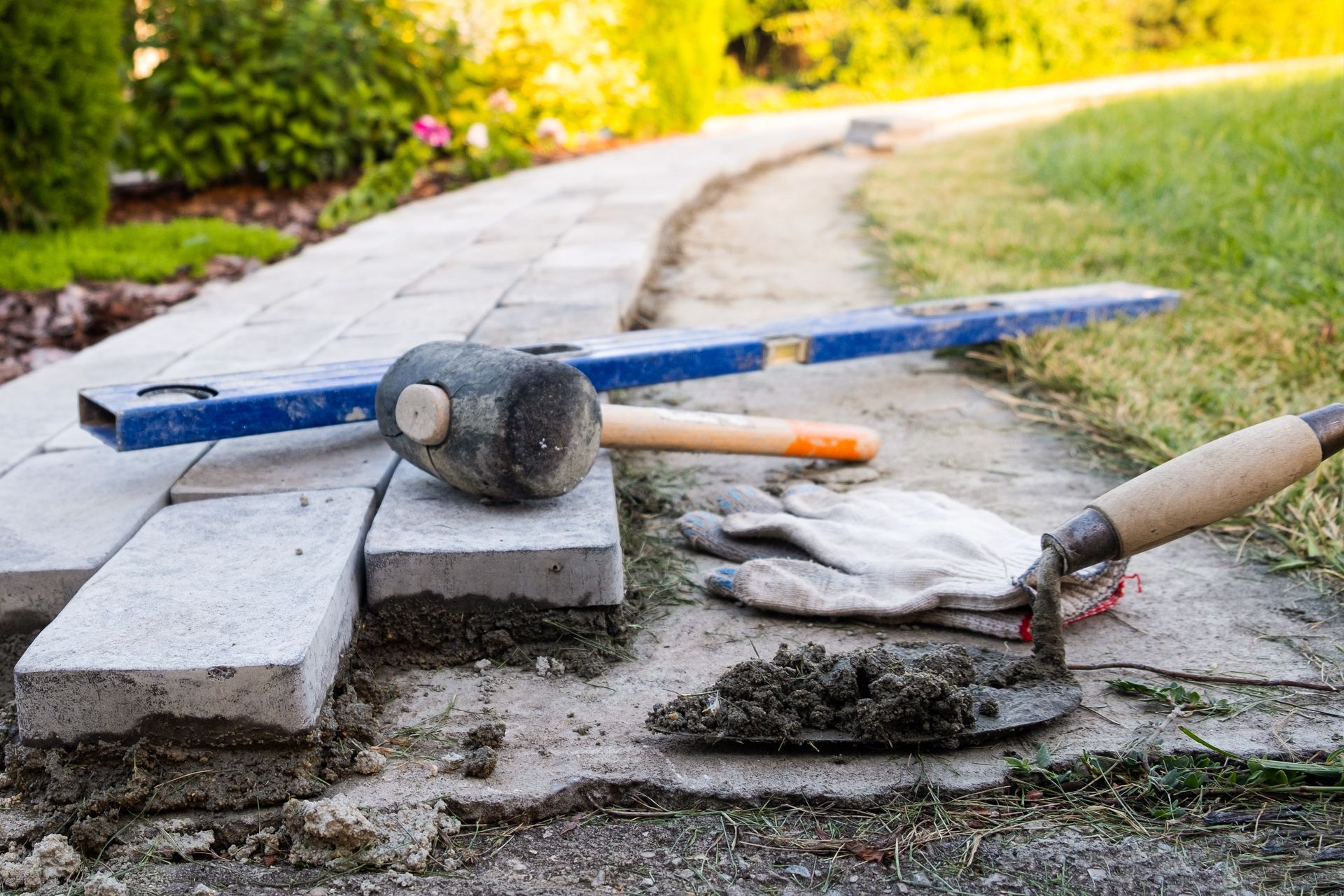 A walkway is being built with bricks and tools.