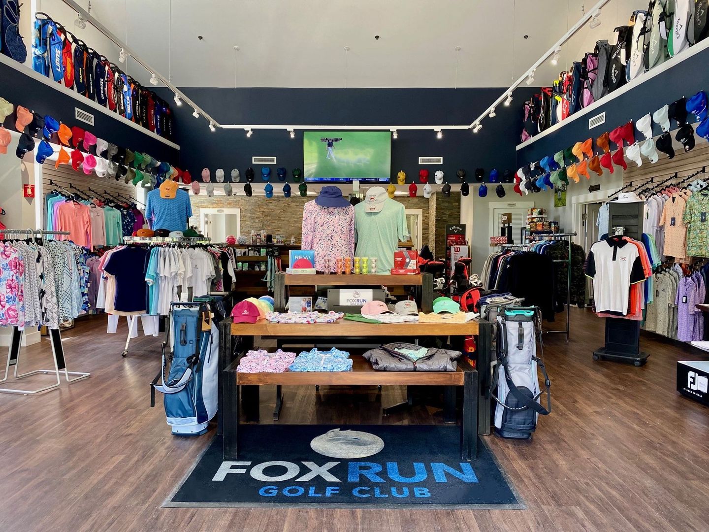 A fox run golf club store filled with lots of clothes and bags.