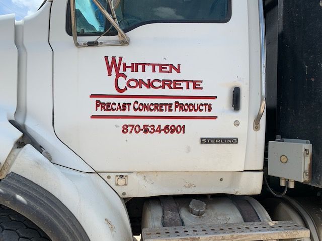 Whitten Concrete truck cab with company logo and phone number on white door