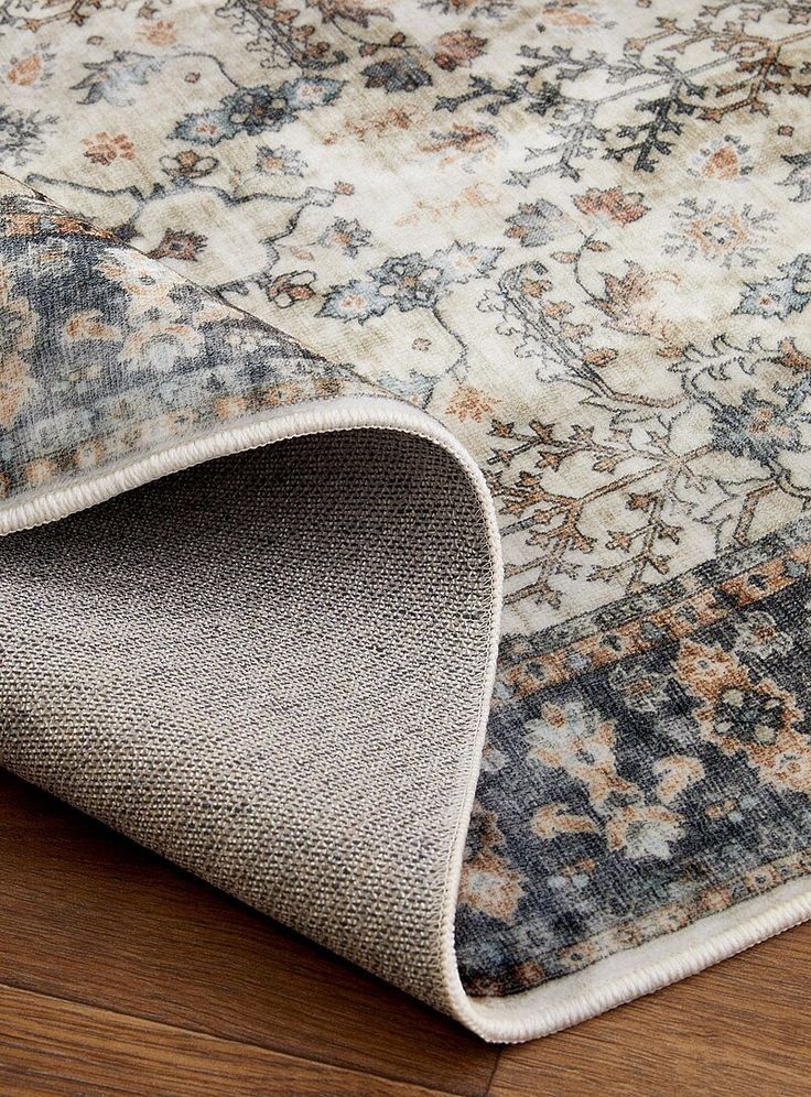 Folded Floral Patterned Area Rug With A Beige Underside — Everyday Interiors in Helensburgh, NSW