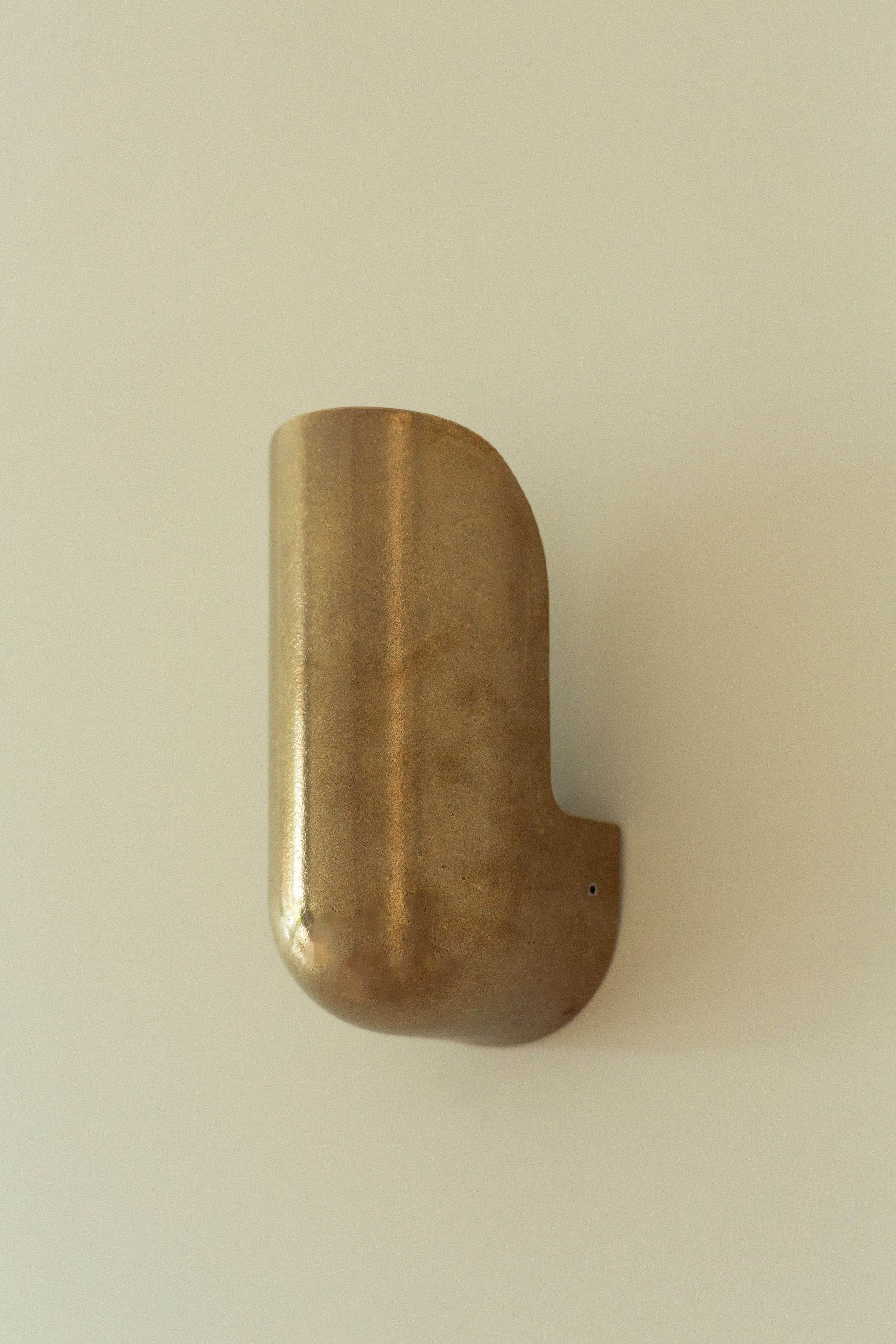 Small Brass Colored Wall Hook Mounted On A Light Beige Surface — Everyday Interiors in Helensburgh, NSW
