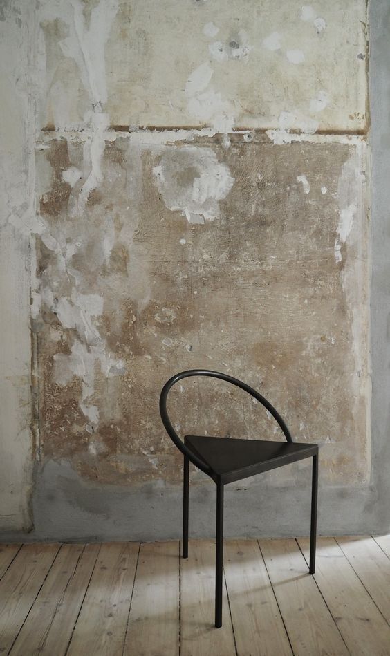 Black Chair Against A Worn Beige Wall In A Minimalist Room With Floorboards — Everyday Interiors in Helensburgh, NSW