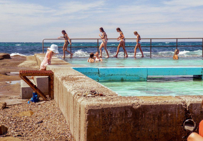 People Walking Along A Concrete Seawall Beside A Turquoise Tidal Pool — Everyday Interiors in Helensburgh, NSW