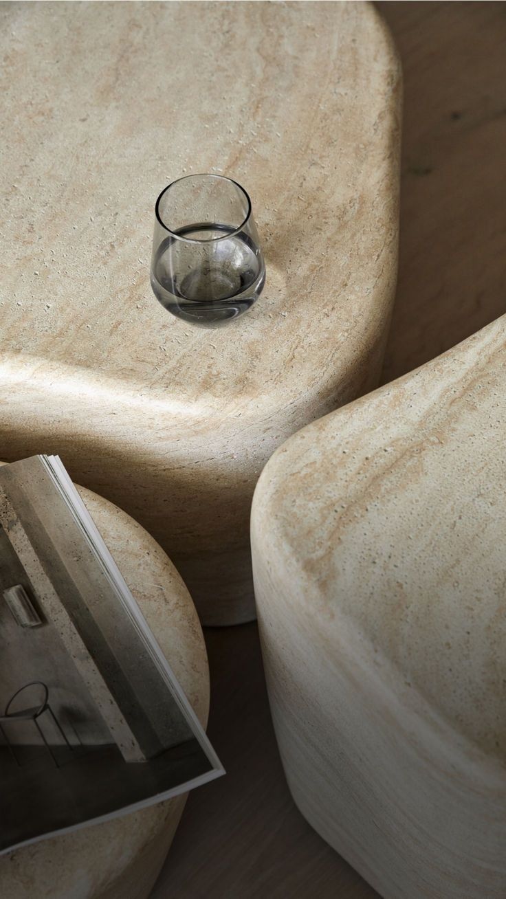 Clear Glass On A Beige Stone Surface Beside A Folded Magazine — Everyday Interiors in Helensburgh, NSW