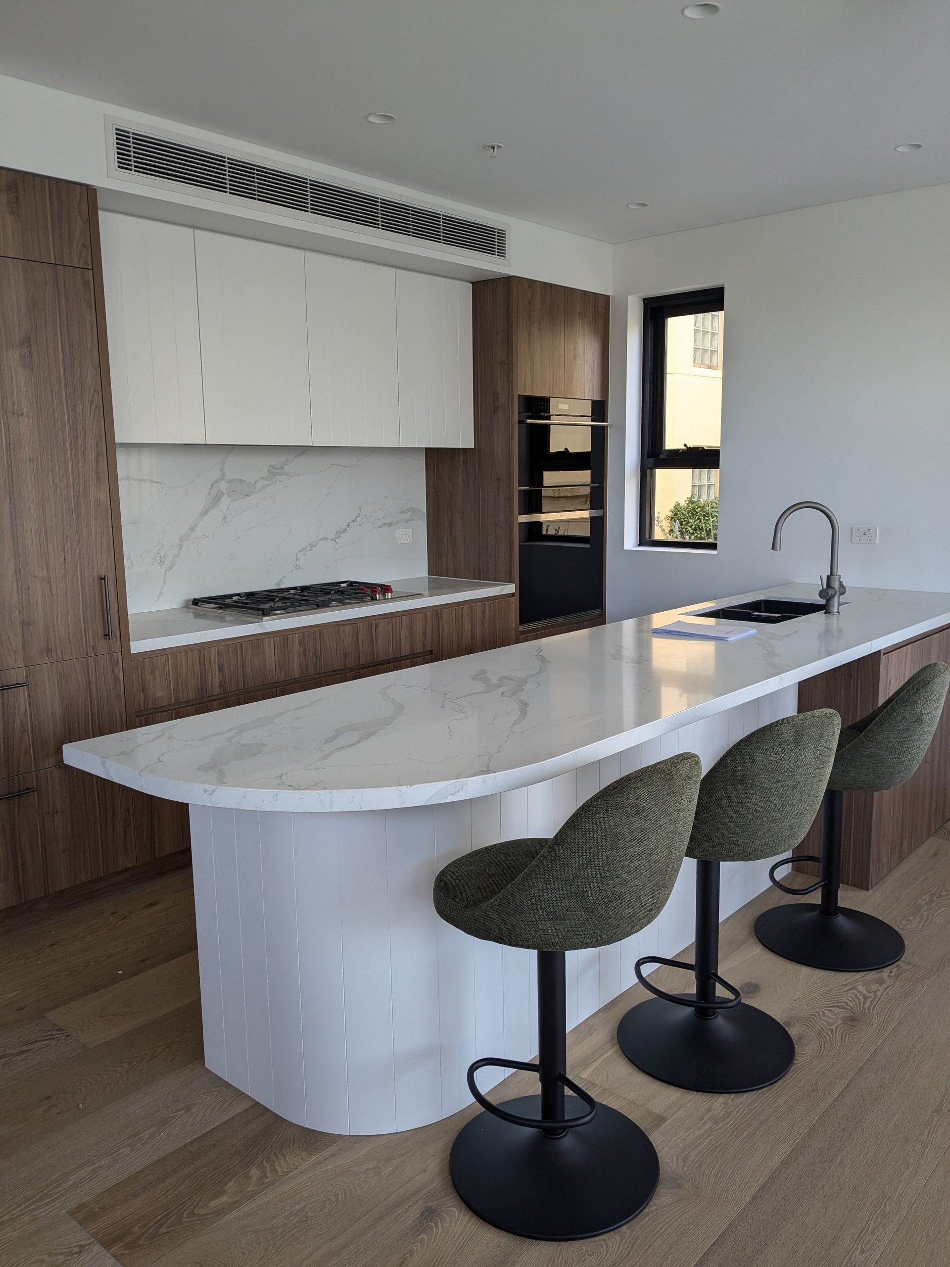 Modern Kitchen With White Curved Island And A Marble Countertop — Everyday Interiors in Helensburgh, NSW