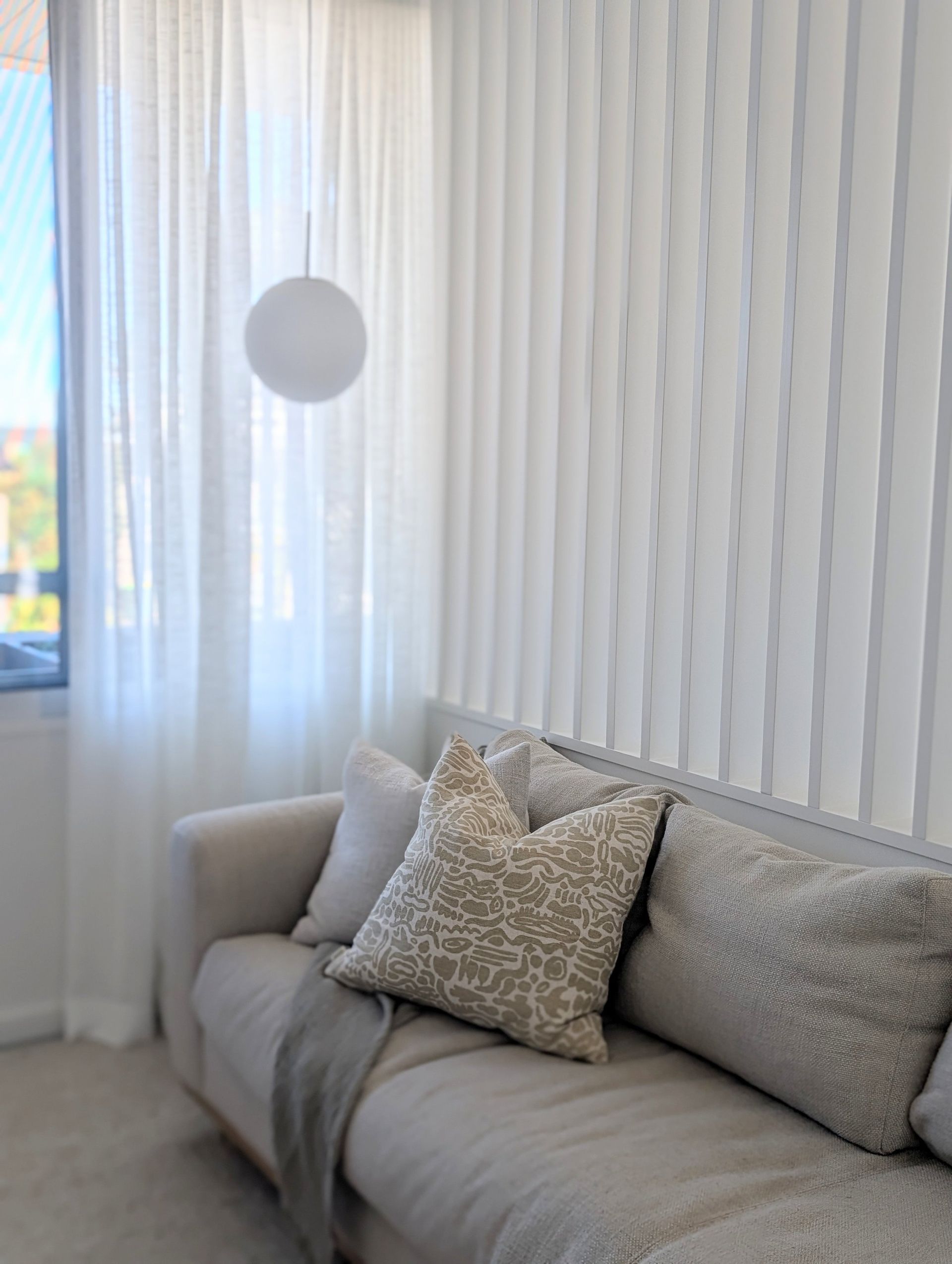 Cozy Beige Sofa With Patterned Cushions Beside Sheer Curtains — Everyday Interiors in Helensburgh, NSW