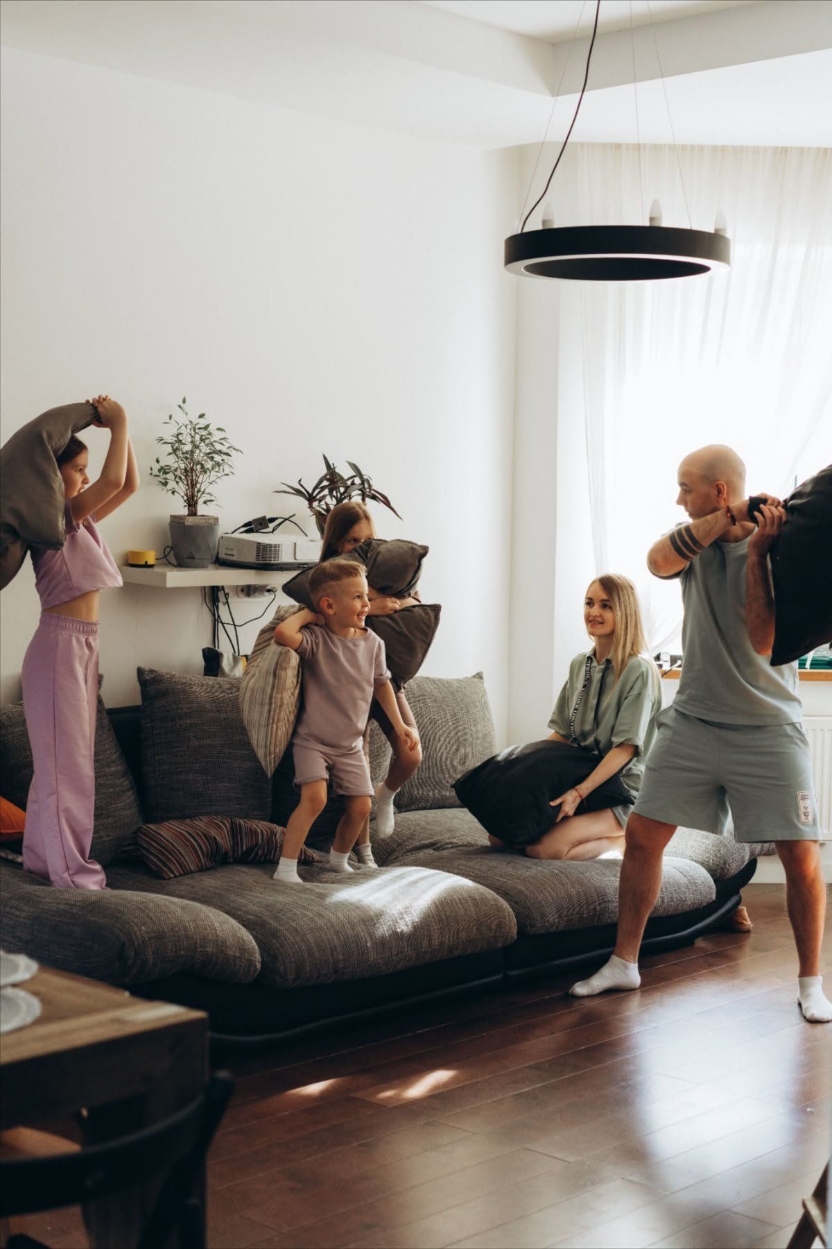 People Dancing And Playing In A Bright Living Room With A Couch — Everyday Interiors in Helensburgh, NSW