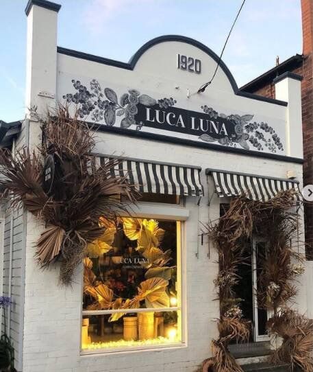 White Storefront With Striped Awning And 