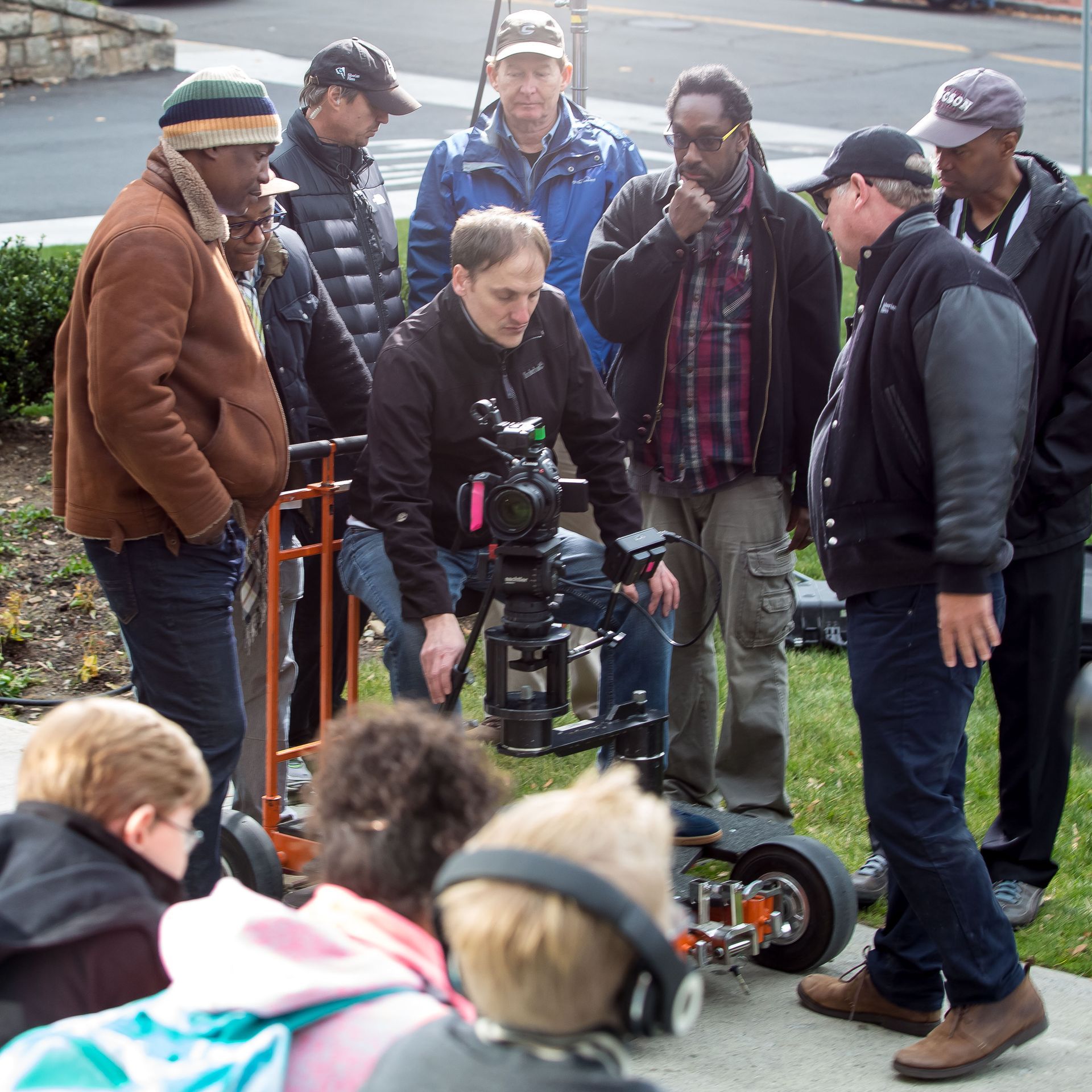 A group of men are gathered around a camera