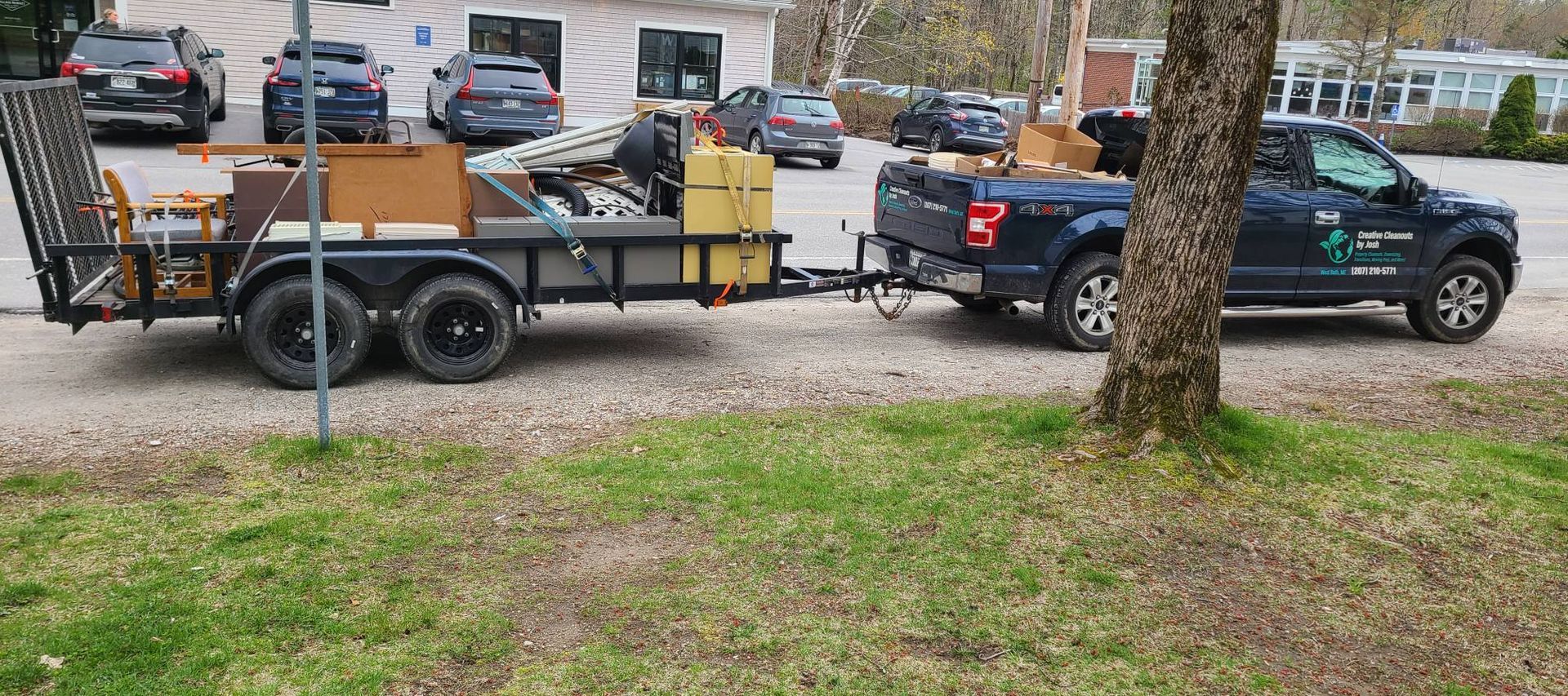 Pickup truck towing a utility trailer loaded with tools and equipment in a parking lot