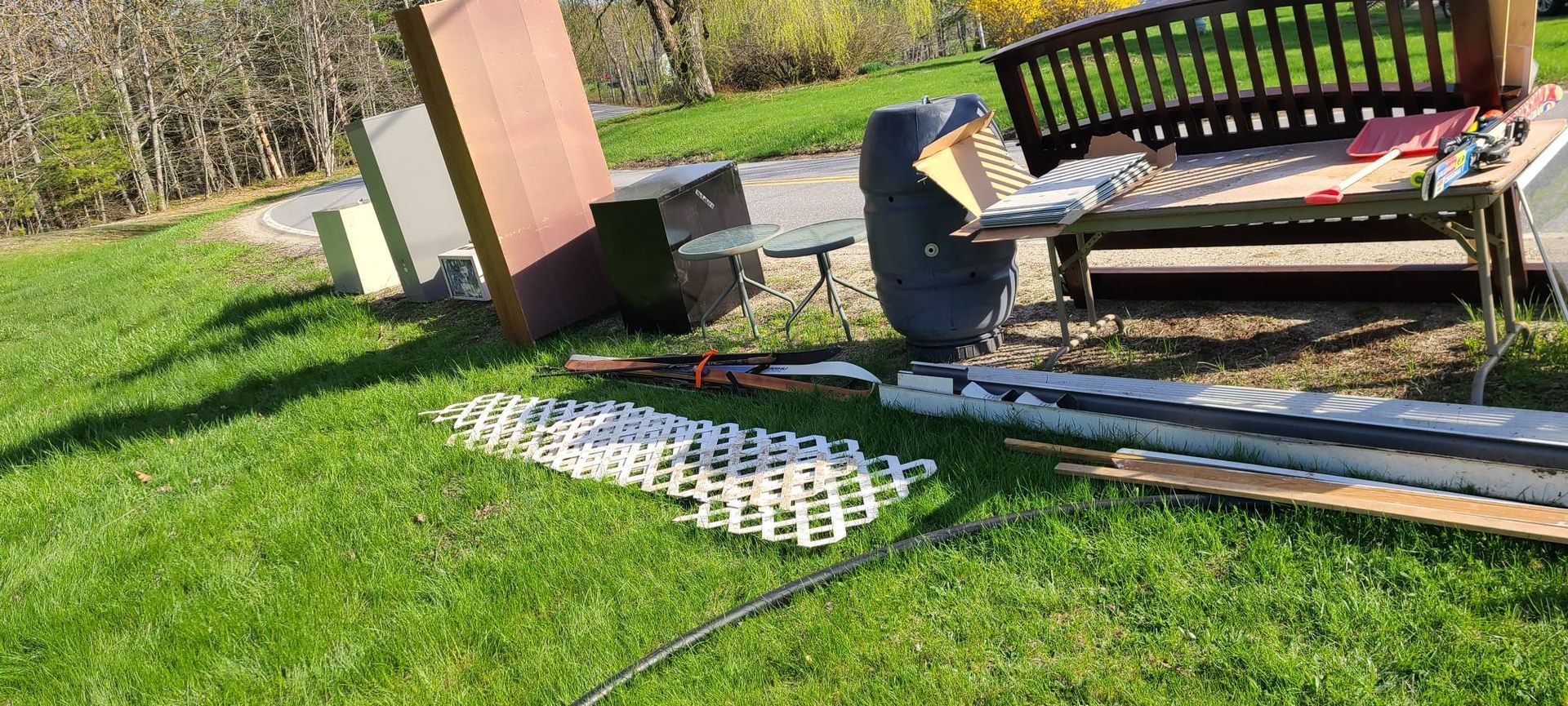 Person measuring patio pavers in a sunny backyard, with a bench and lawn nearby