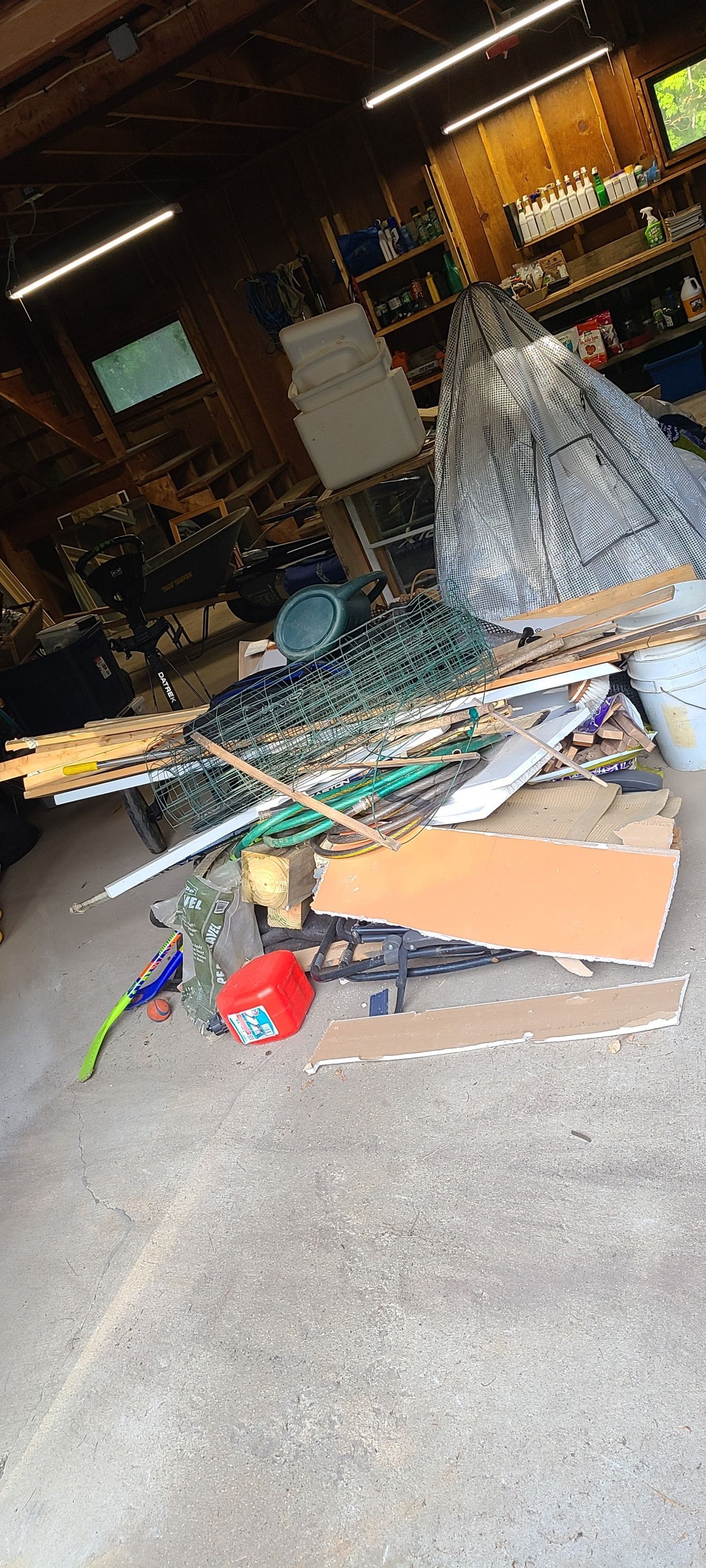 Cluttered workshop floor with broken parts, tools, and a collapsed white mesh structure.