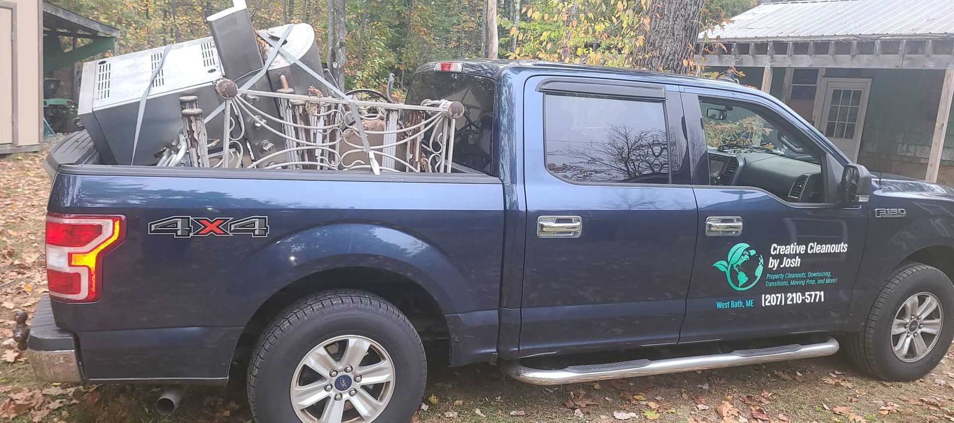 Blue pickup truck with satellite equipment and logos parked outdoors by a building