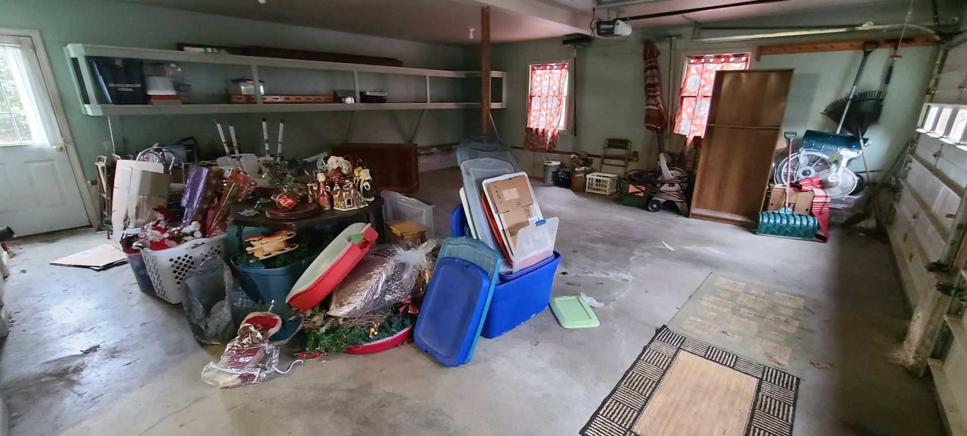 Cluttered garage or basement filled with piles of trash, bags, and bins, with a ladder on the wall.