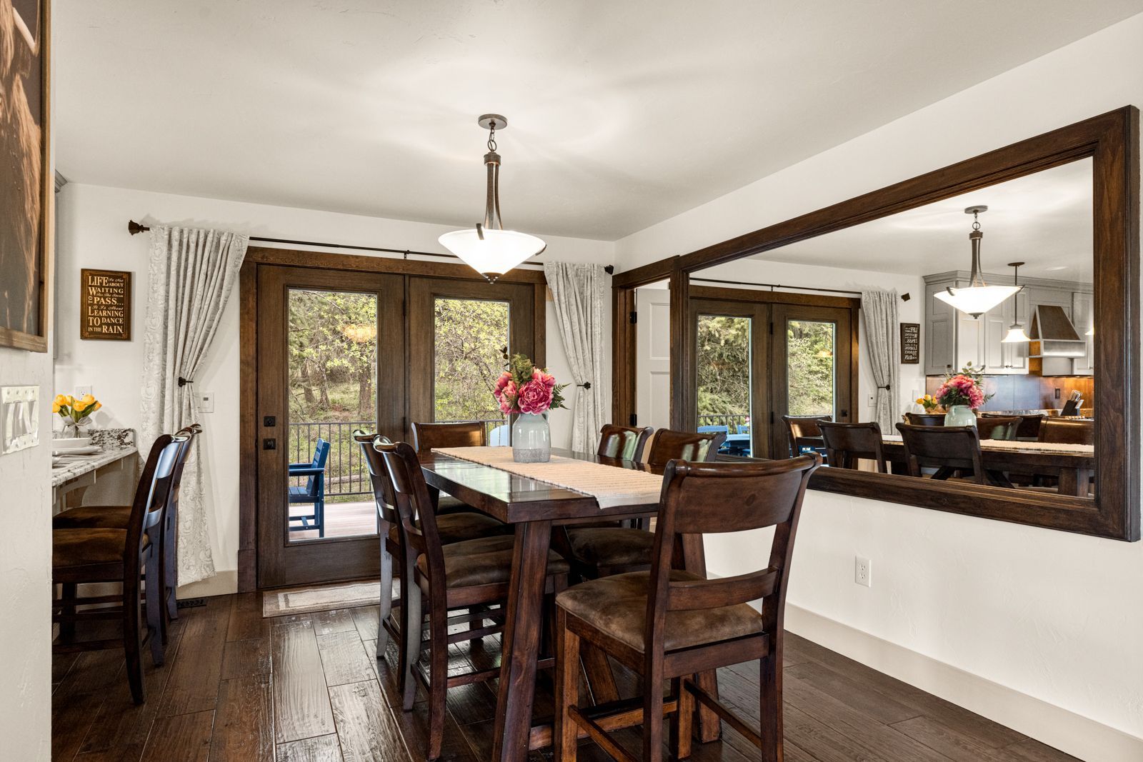 Dining room with dark wood table, large wall mirror, and sliding glass doors to a patio.