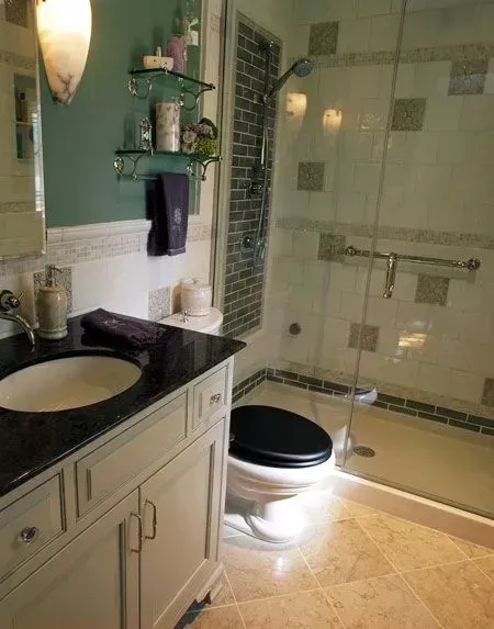 Bathroom with black-and-white vanity, tub, and lit toilet seat in a tiled, green-painted room in a modern kitchen with gray cabinets, island, pendant lights, exposed wood beams, and two barstools in Arlington Heights, IL.