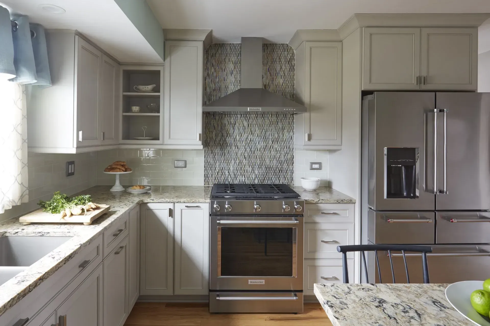 Bright modern kitchen with white cabinets, stainless steel appliances, and a tiled backsplash in Long Grove, IL