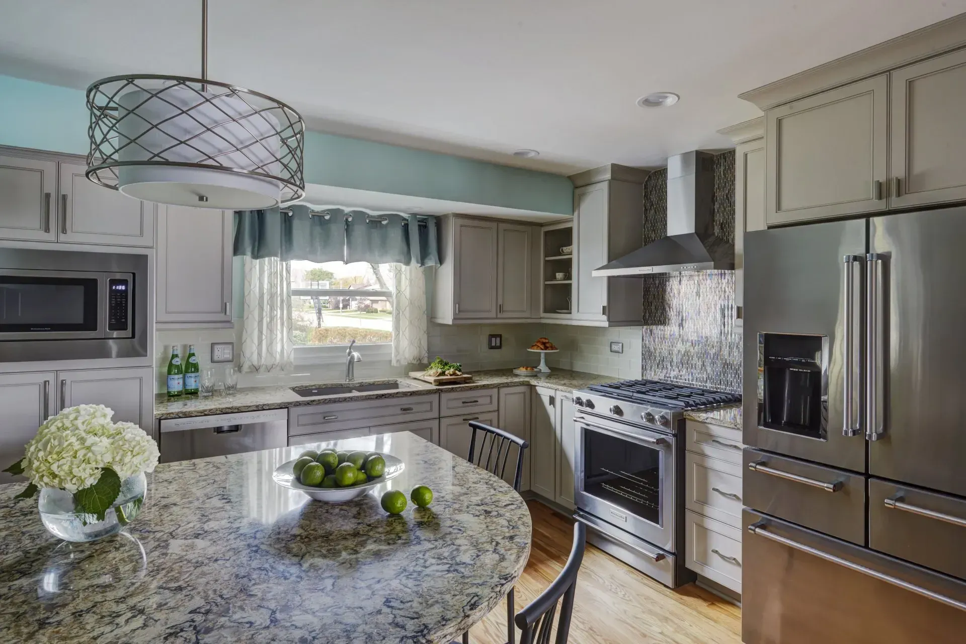Modern kitchen with granite island, stainless steel appliances, and a window over the sink in Hawthorn Woods, IL.