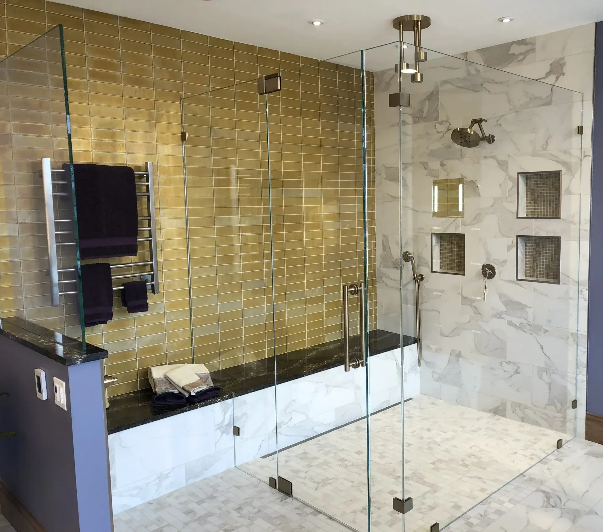Modern bathroom with glass shower, marble tile, and gold mosaic accent wall in Modern kitchen with gray cabinets, island, pendant lights, exposed wood beams, and two barstools in Arlington Heights, IL.