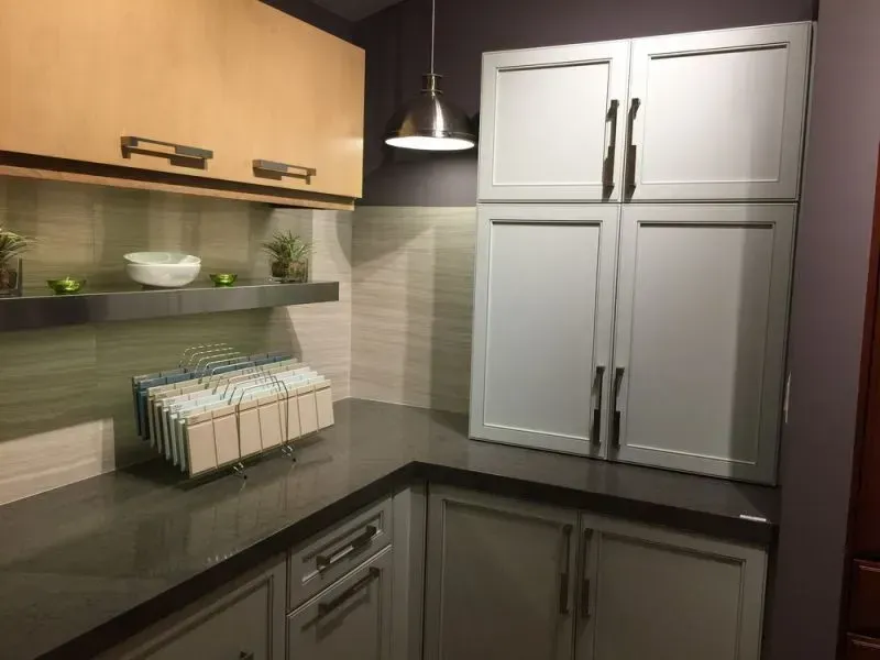 Modern kitchen with dark countertop, white cabinets, and wooden upper cabinets in Modern kitchen with gray cabinets, island, pendant lights, exposed wood beams, and two barstools in Arlington Heights, IL.