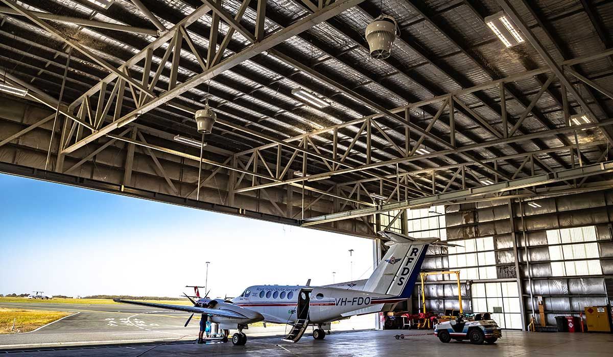 Inside a hanger with a small aeroplane 