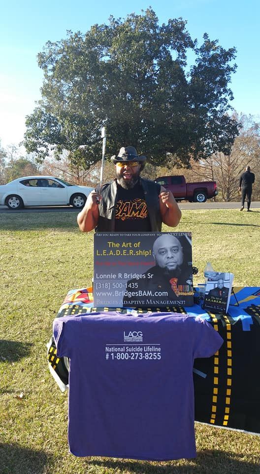 A man is standing in front of a table with a purple shirt on it.