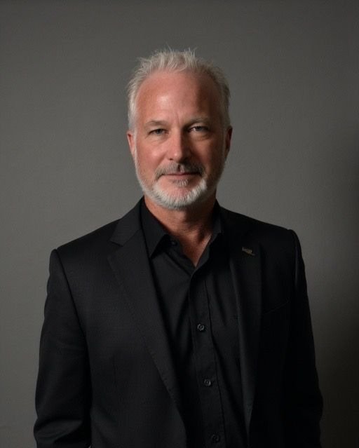A man with a beard is wearing a suit and tie and smiling.